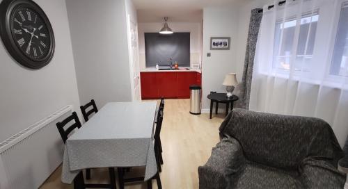 een woonkamer met een tafel, een stoel en een klok bij Apartment in the heart of wexford town in Wexford