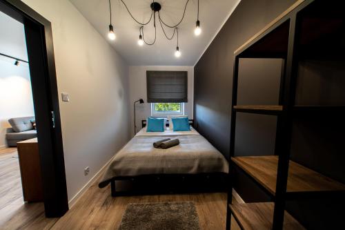 a bedroom with a bed with blue pillows at Apartamenty Biłgoraj in Biłgoraj