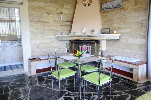 comedor con mesa, sillas y chimenea en Iro - Kostas House 1, en Chalkida