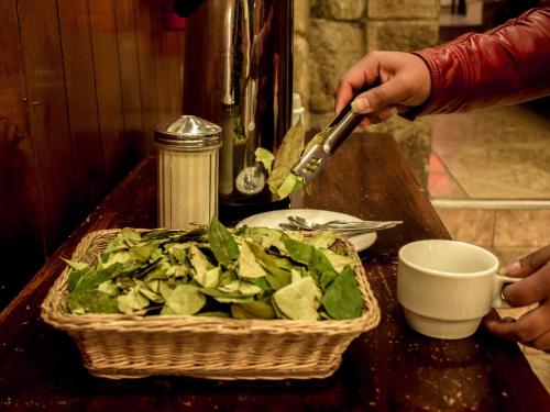 een persoon met een mes en een mand met sla bij SAN BLAS PLAZA INn in Cuzco