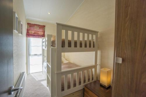 a small room with a bunk bed in a house at Chalet M6, The Warren, Abersoch in Abersoch