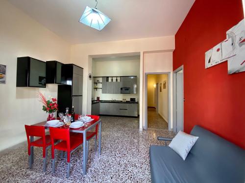 un soggiorno con tavolo e parete rossa di La Casa di Anita a Cefalù