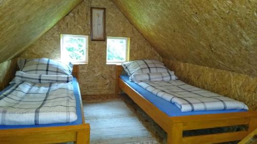 a room with two beds in a attic at Domek Łukaszówka in Jonkowo