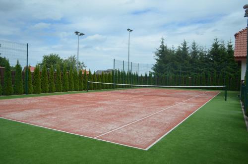a tennis court with a net on top of it at Domek nad jeziorem in Dąbrówno