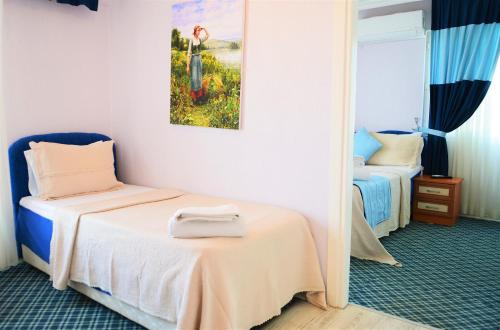 A bed or beds in a room at Gumuldur Mavi Deniz Hotel