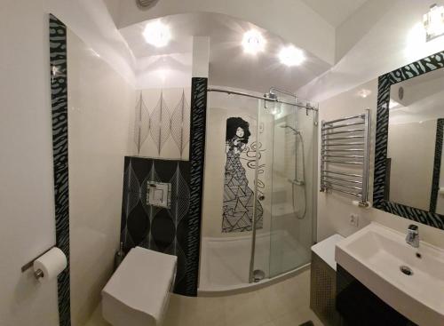a bathroom with a glass shower and a sink at Wigwam Apartament 8-osobowy in Sopot