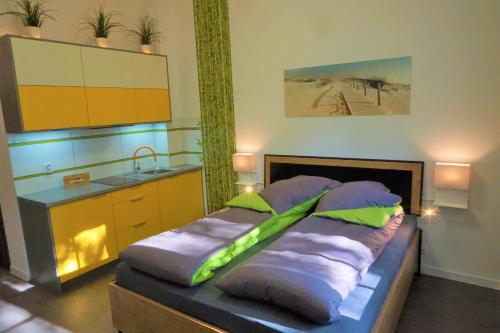 ein Schlafzimmer mit einem Bett mit Kissen und einem Waschbecken in der Unterkunft Usedom-Apartment in Świnoujście