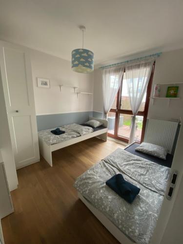 - une chambre avec 2 lits et une fenêtre dans l'établissement Błękitny Apartament - Wilanów, à Varsovie