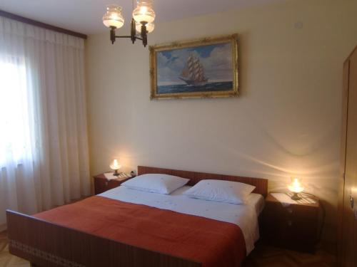 a bedroom with a bed and a painting on the wall at Apartment Marija in Krk