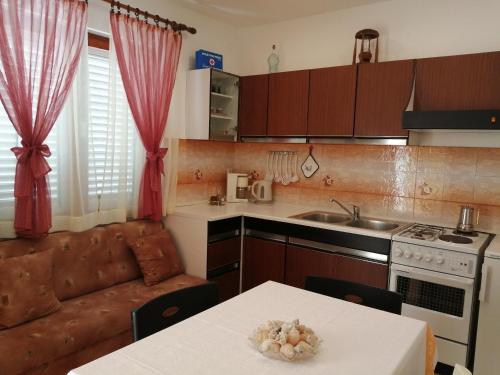 a kitchen with a table and a couch in a room at Apartment Marija in Krk