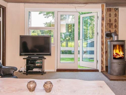 salon z telewizorem i kominkiem w obiekcie 4 person holiday home in Haderslev w mieście Haderslev