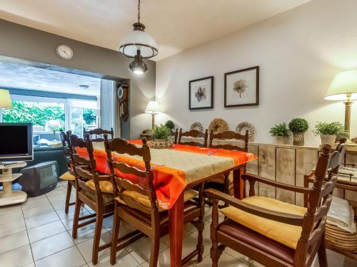 een eetkamer met een tafel en stoelen bij Holiday Home with Terrace Garden Parking in Uikhoven