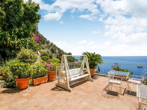 a patio with a bench and plants and the ocean at Belvilla by OYO Arienzo in Positano