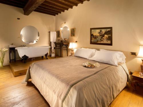 sypialnia z dużym łóżkiem i wanną w obiekcie Graziella Patio Hotel w Arezzo
