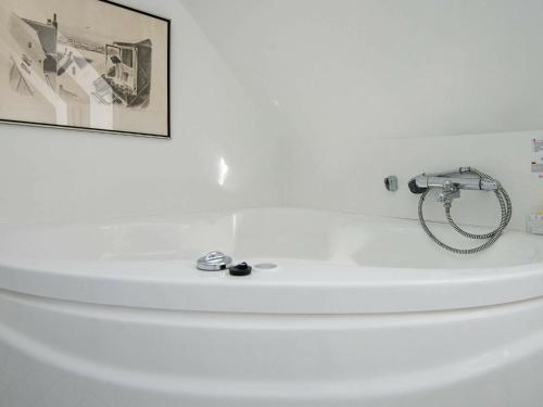 a bathroom with a white tub with a picture on the wall at 8 person holiday home in Haderslev in Kelstrup Strand