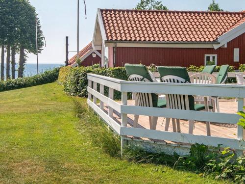 une clôture blanche avec des chaises devant une maison rouge dans l'établissement 8 person holiday home in Haderslev, à Kelstrup Strand