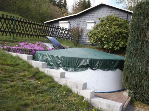 a table with a green tarp on it in a yard at Holiday home in Thuringia in Neuhaus am Rennweg