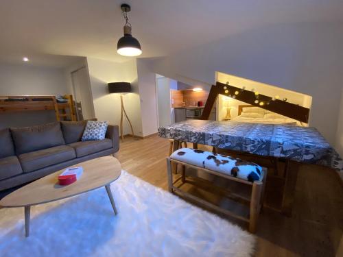 ein Wohnzimmer mit einem großen Bett und einem Sofa in der Unterkunft Joli studio rénové au coeur de Cauterets in Cauterets