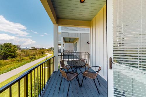 a porch with two chairs and a table on it at West Side Cottage #OO in Gulf Shores