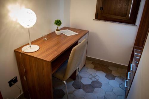 a desk with a lamp and a plant on it at Alterego B&B in Milazzo