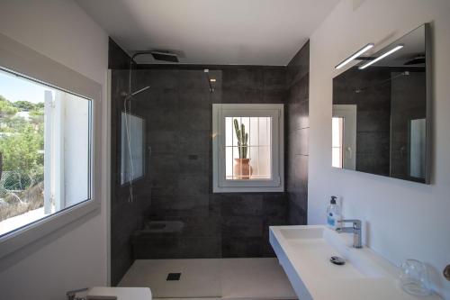 een badkamer met een wastafel en een douche bij Villa Arola in Cala Comte