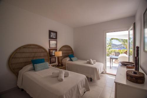 Un dormitorio con dos camas y un balcón. en Villa Arola, en Cala Comte