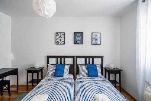 Downtown Apartment Helena في أوباتيا: غرفة نوم بسريرين مع وسائد زرقاء وبيضاء