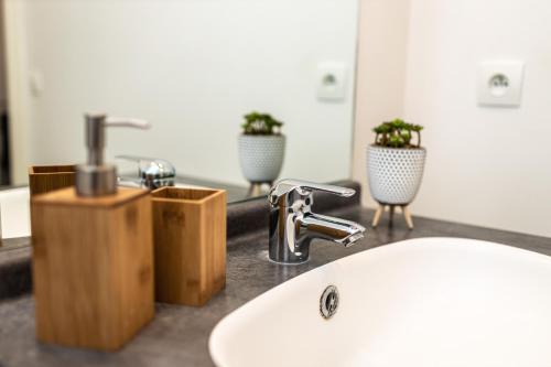 - un lavabo avec deux plantes en pot devant un miroir dans l'établissement La Suite Arcade - SDP, à Magny-le-Hongre