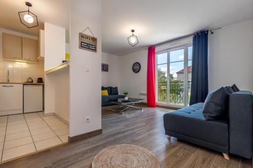 un salon avec un canapé bleu et une cuisine dans l'établissement La Suite Arcade - SDP, à Magny-le-Hongre