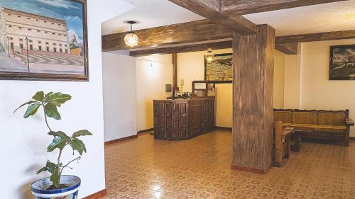 een woonkamer met een potplant en een houten pilaar bij Hotel Alhóndiga in Guanajuato