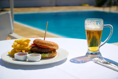 Hamburger und Pommes Frites und ein Glas Bier in der Unterkunft Villa Christina Skiathos in Vromolimnos