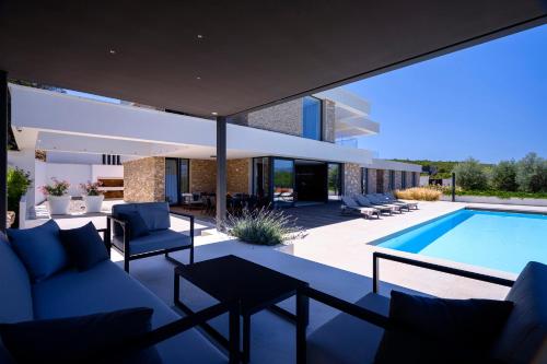 a villa with a swimming pool and a house at Villa Eola Hvar in Jelsa