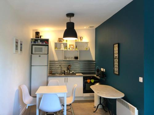 une petite cuisine avec une table et un réfrigérateur dans l'établissement Royantine, à Aubagne