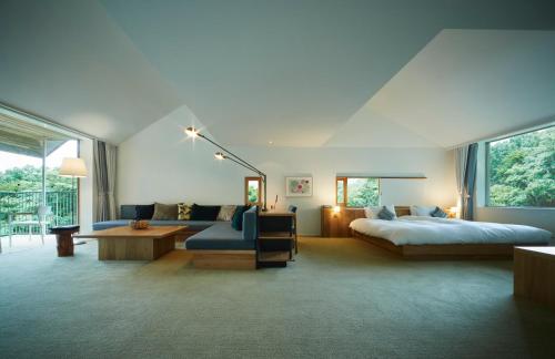 a bedroom with a bed and a couch and a table at Hakone Retreat Före in Hakone