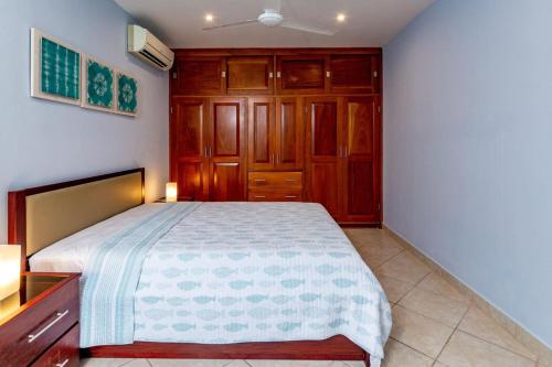 a bedroom with a bed and wooden cabinets at 2-Bedroom Condo with Ocean View and Pool in Playa Flamingo
