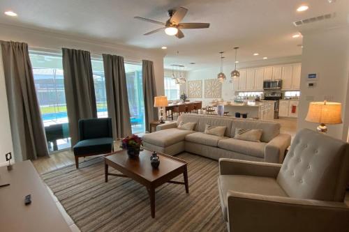a living room with a couch and a table and a kitchen at 3840 Supreme Villa 6Bd Private Pool and Game Room in Kissimmee