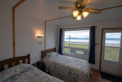 a bedroom with two beds and a large window at Sea Breeze Motel in Ingonish
