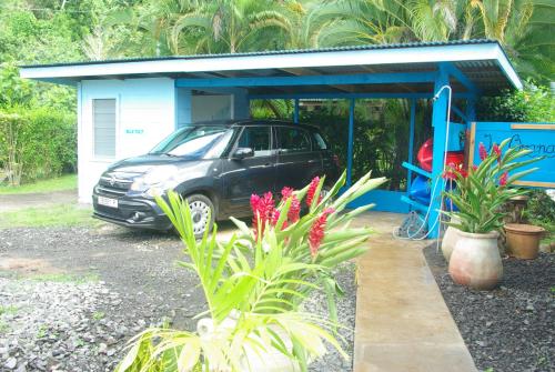 a car parked in front of a small house at bungalow chez sofpat in Uturoa