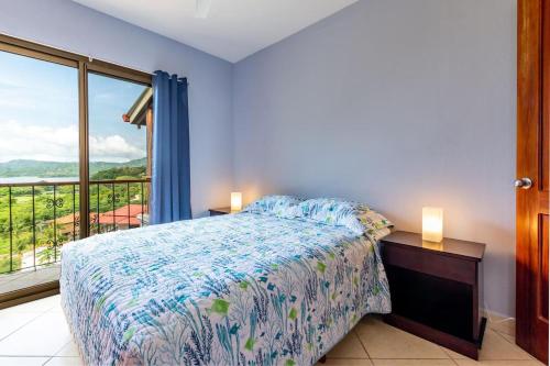 a bedroom with a bed and a large window at 2-Bedroom Ocean-View Condo with Pool in Playa Flamingo