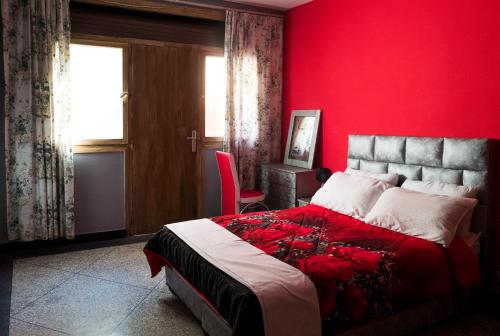 Modern and Cozy Apartment في الدار البيضاء: غرفة نوم حمراء بسرير وجدار احمر