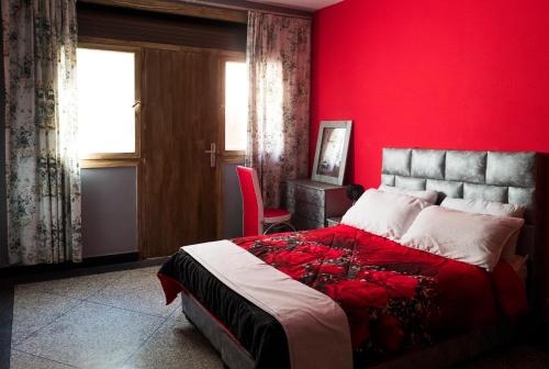 une chambre rouge avec un lit et un mur rouge dans l'établissement Modern and Cozy Apartment, à Casablanca