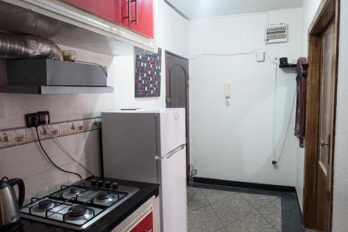 Modern and Cozy Apartment في الدار البيضاء: مطبخ مع موقد وثلاجة بيضاء