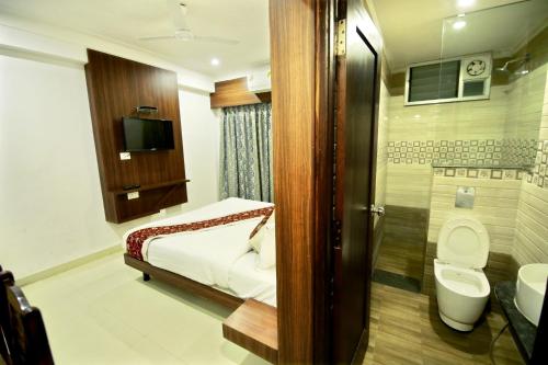 a bathroom with a bed and a toilet and a sink at Hotel Sunflower Udaipur in Udaipur
