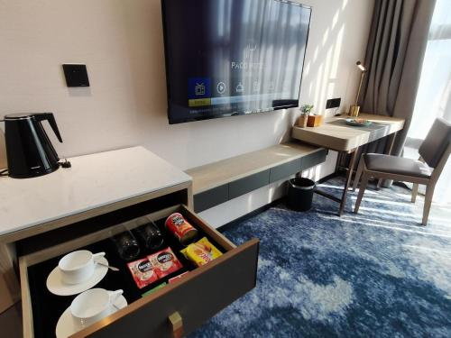 a hotel room with a kitchen with a table and a desk at Paco Hotel Jinfeng Metro Guangzhou-Free Shuttle Bus For Canton Fair-Self-service laundry in Guangzhou