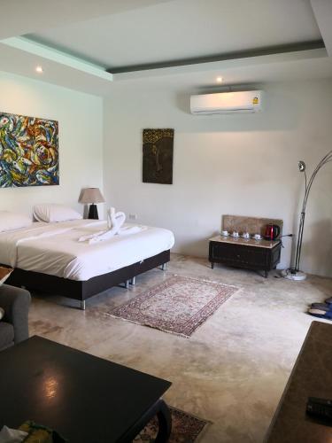 a bedroom with a large bed and a couch at Tropical House​ in Hua Hin