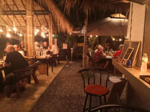 a group of people sitting at tables in a restaurant at Tropical House​ in Hua Hin