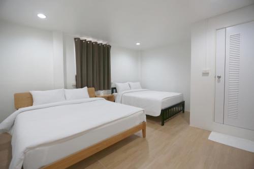 a hotel room with two beds and a window at INTERest POSHTEL in Bangkok