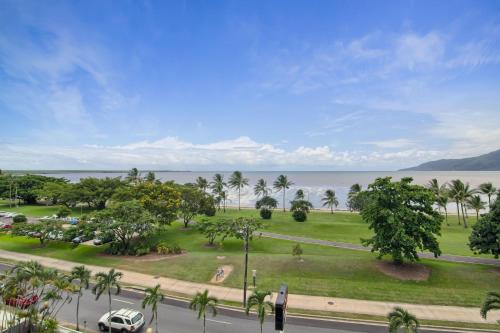 a view of a park with palm trees and a street at Acacia Court Hotel in Cairns