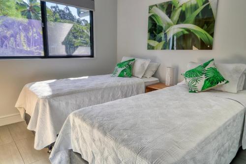 a room with two beds and a couch at Valle Vista Luxury Apartments in Cairns