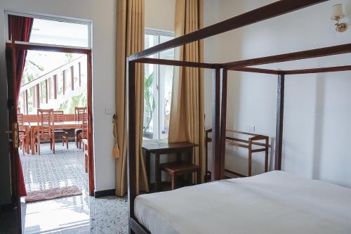 a bedroom with a bed and a table and chairs at Sunset View Beach Hotel in Arugam Bay